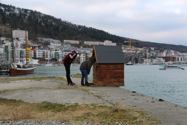 A tiny wooden house at a quaint with an analogue mareograph inside