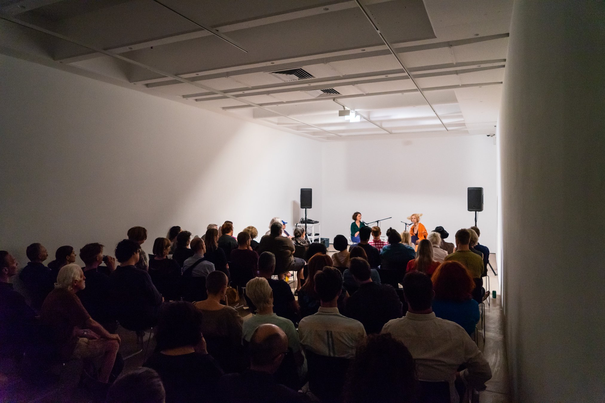 Gathering of people listening to two female speakers