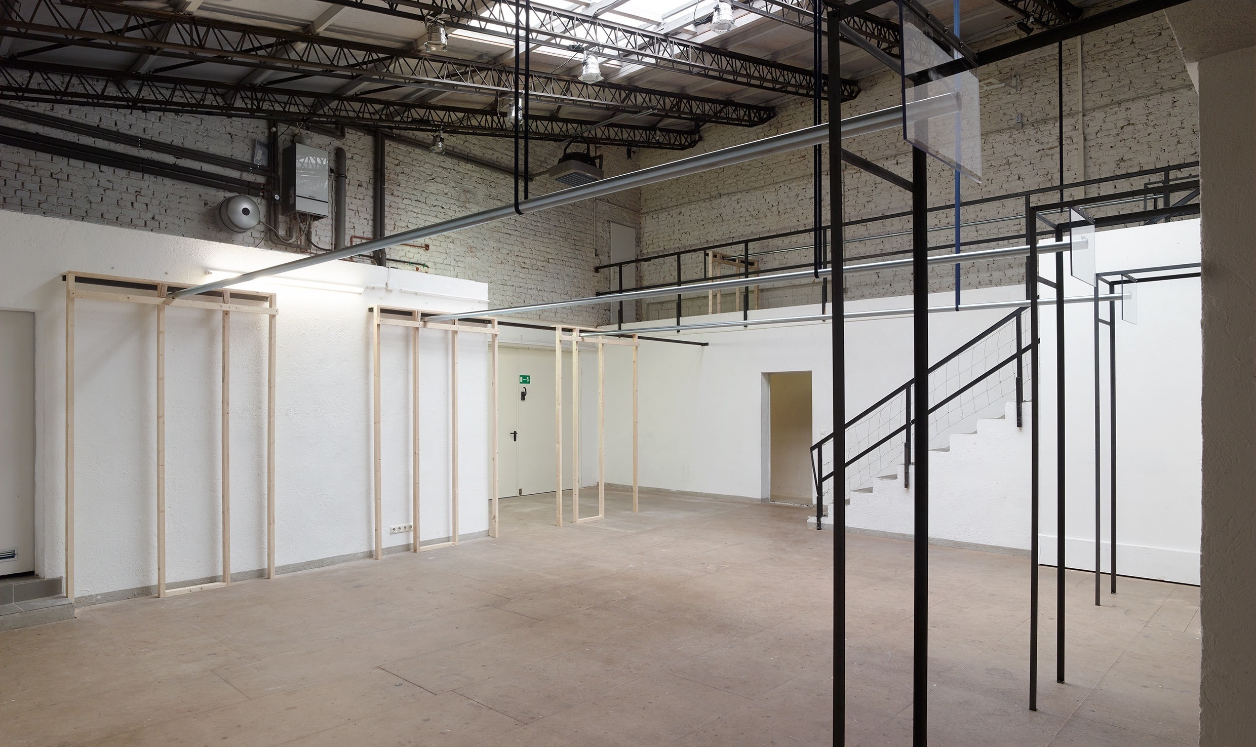 Steel tubes hanging from rotating belts, rolling on custom wooden frames in a factory. Moving in a repetitive manner producing nothing but changing frequencies and wear and tear.