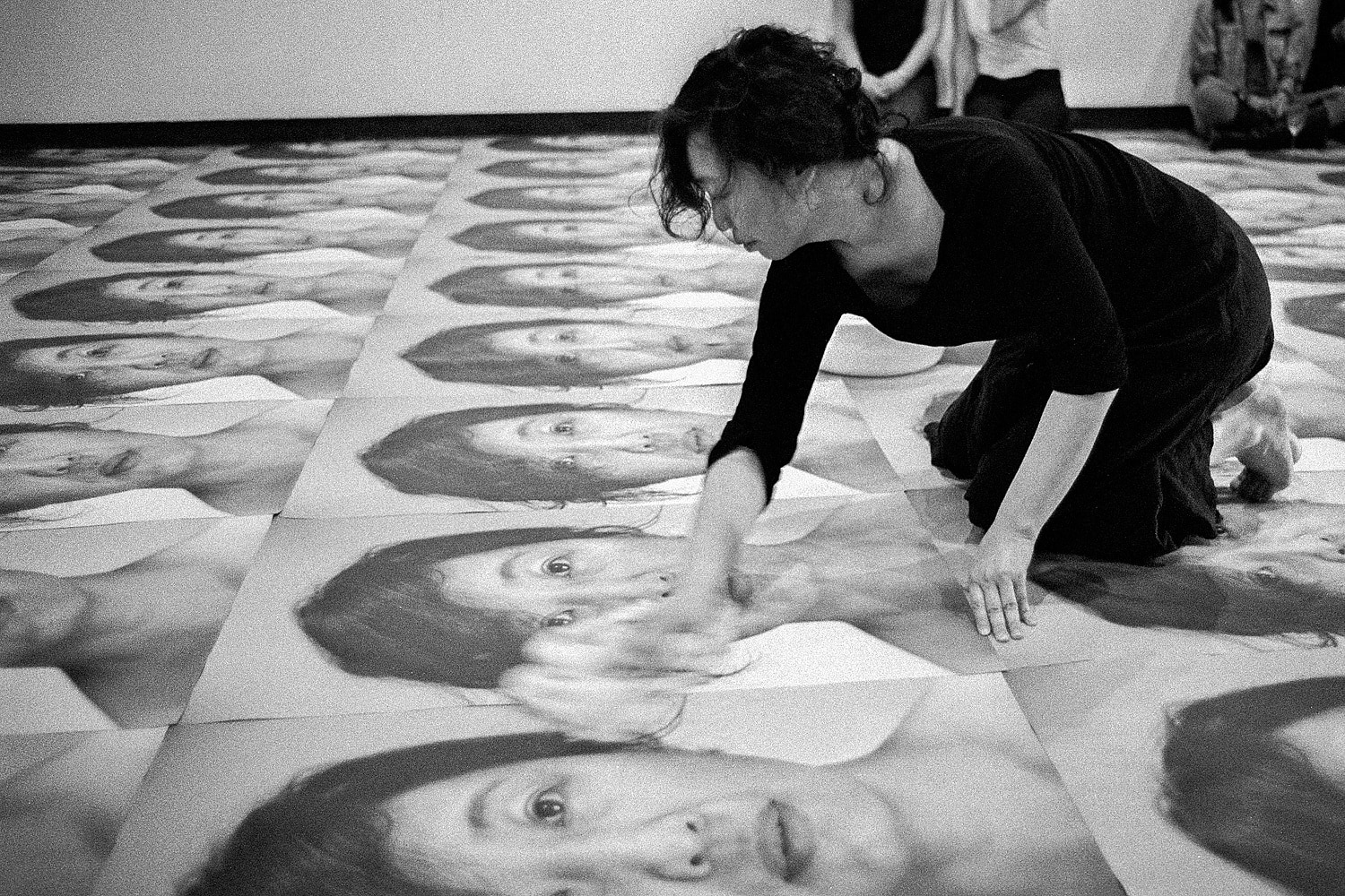 Multiple digital self-portraits are installed on the gallery floor. I conduct a performance as part of this installation in which I wash the photographs after they have been walked on by visitors and then use the water to wash my face.