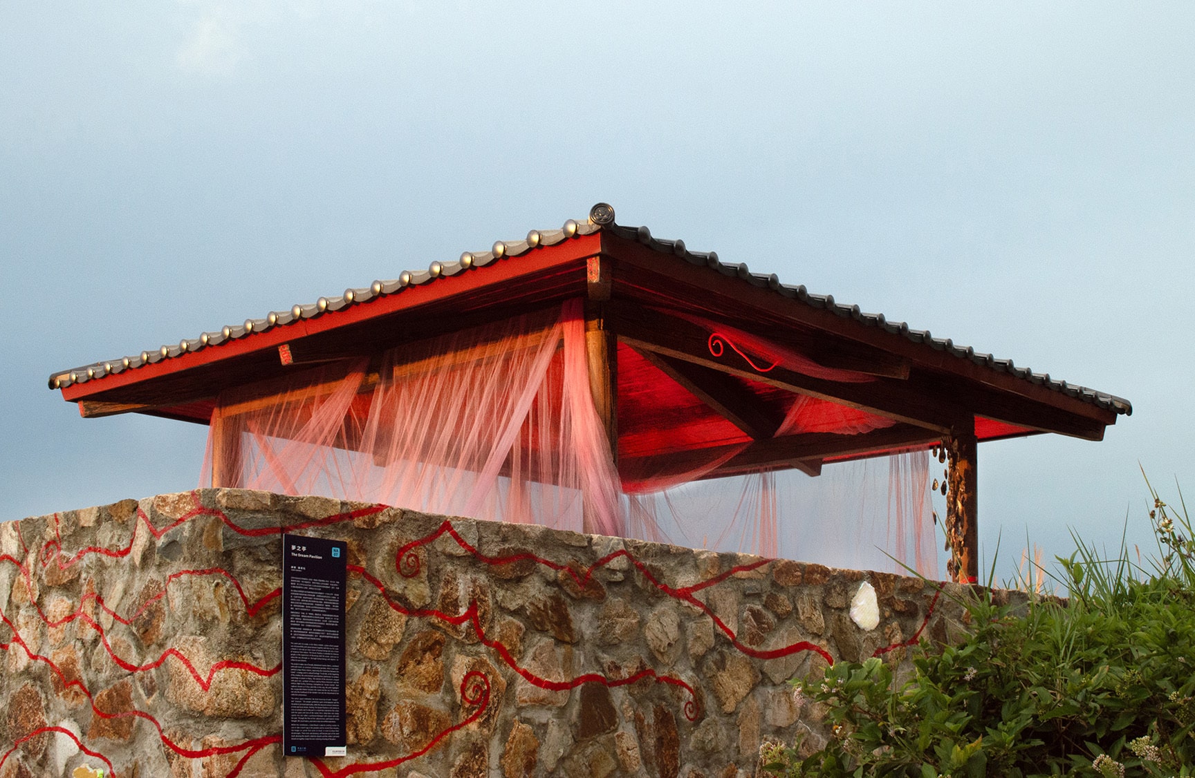 “The Dream Pavilion” reflects Matsu's nature and history through dreams. The work uses a local building as a canvas, applying fishing nets, mirrorred film in sunset hues, and wall paintings as interventions on space, setting up a place where people can dream together with the ocean, and where the ocean can rest at ease with the people.